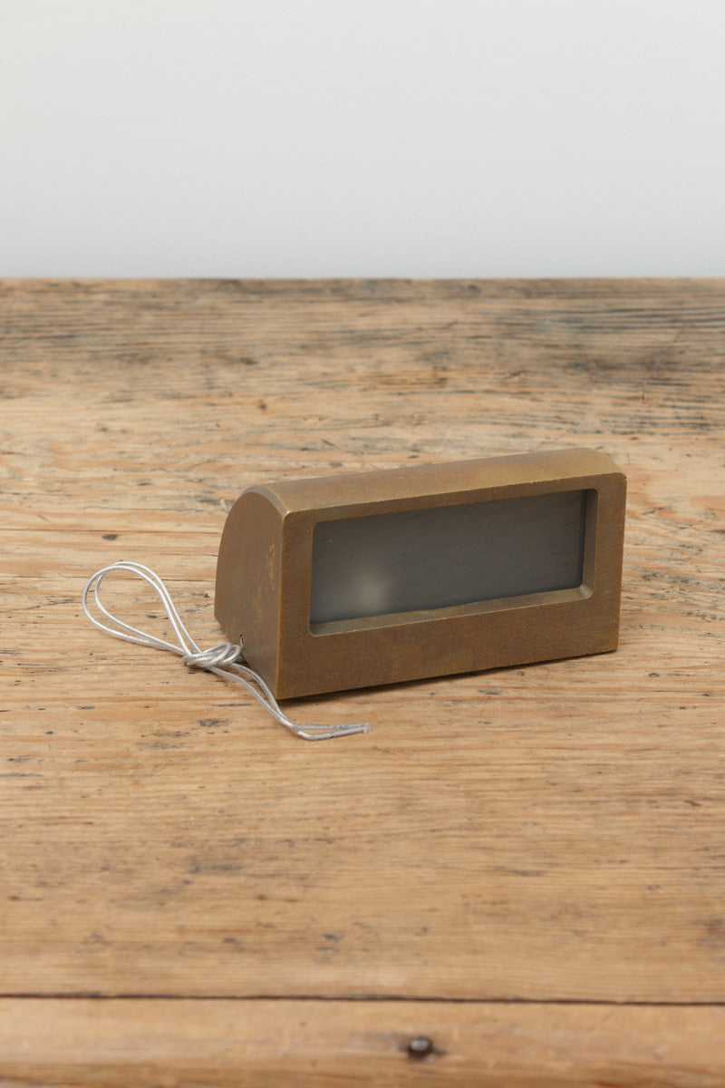 Large step light in light aged bronze finish on a timber bench.