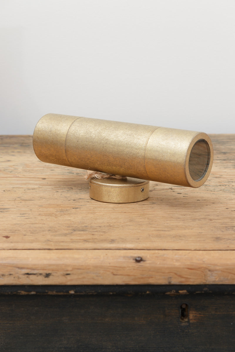 Antique Brass up/down wall light with IP65 rating on a timber bench. 