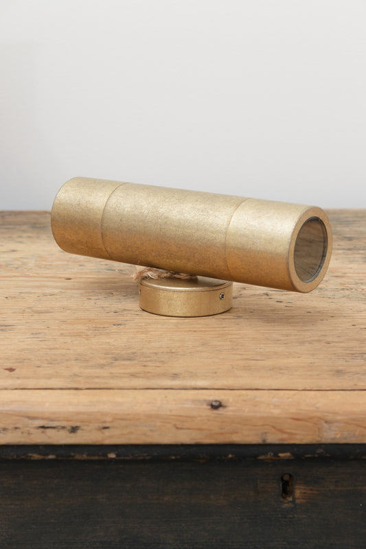 Antique Brass up/down wall light with IP65 rating on a timber bench. 