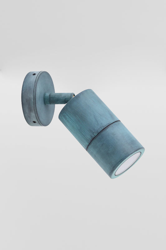 Solid brass adjustable wall light with a green patina finish