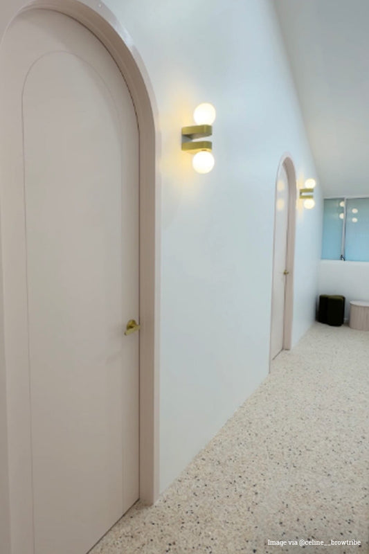 Hallway with arched doorways and double wall lights in gold brass
