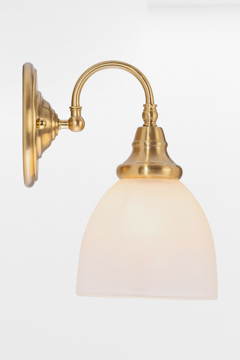 Illuminated Satin Brass wall sconce with gooseneck arm facing down and an opal shade. 