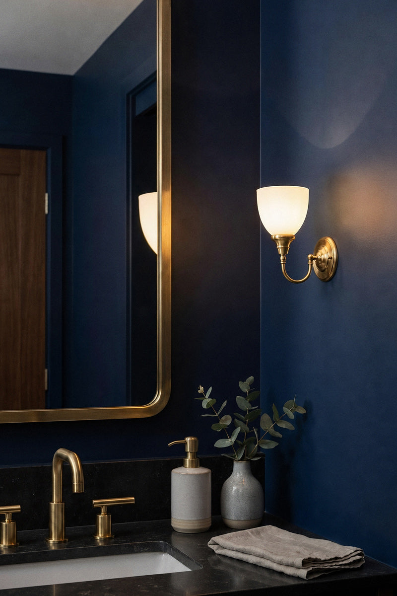 Satin Brass gooseneck wall light with an open opal glass shade in a richly texture navy and brass fitted bathroom.