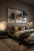 Large clear glass wall light with black sconce in a bedroom 