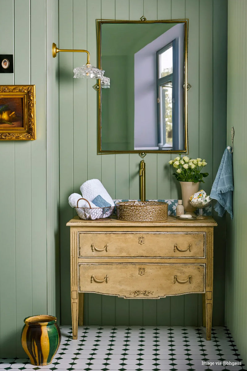 Image vis @bbgaus: Vintage clear glass shade on a gold/brass 90 degree wall arm in a green wall panelled bathroom with traditionally style vanity. 