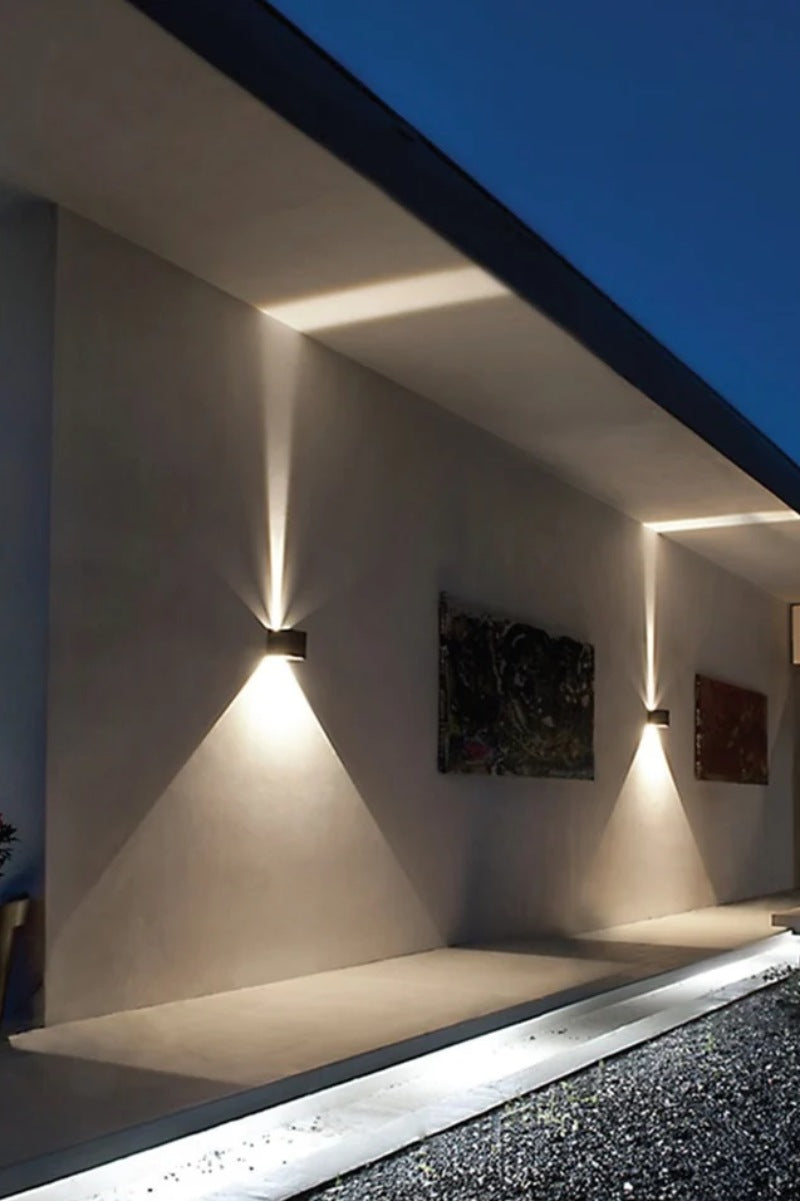 Two small wall lights on a concrete style wall. 