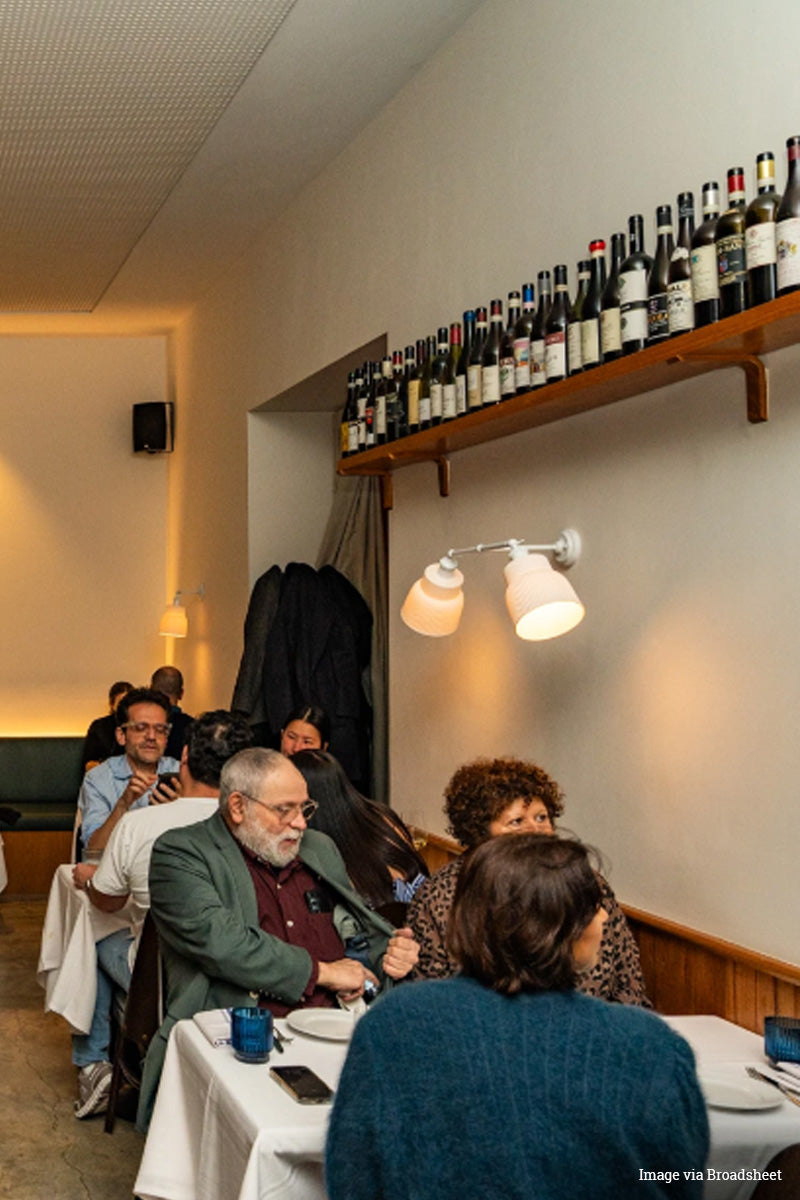 People dining at a restaurant with double arm wall light in white