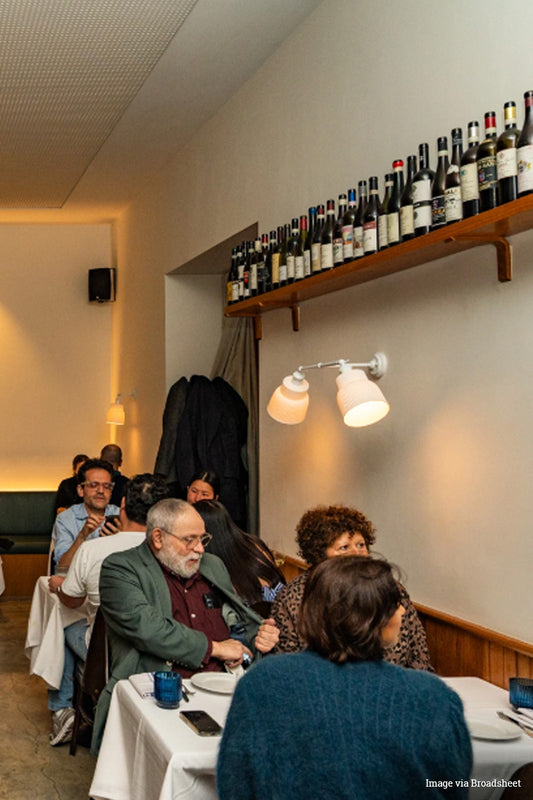 People dining at a restaurant with double arm wall light in white