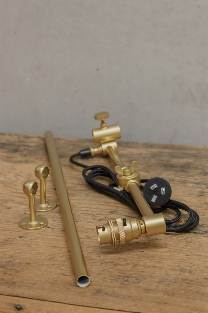 Gold swing arm wall sconce with black plug in cord