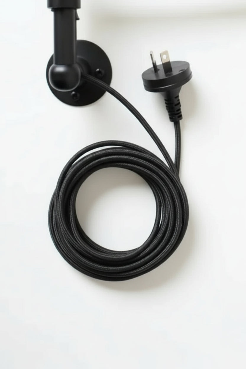 Close up of the Black wall mount with black cord and plug. 