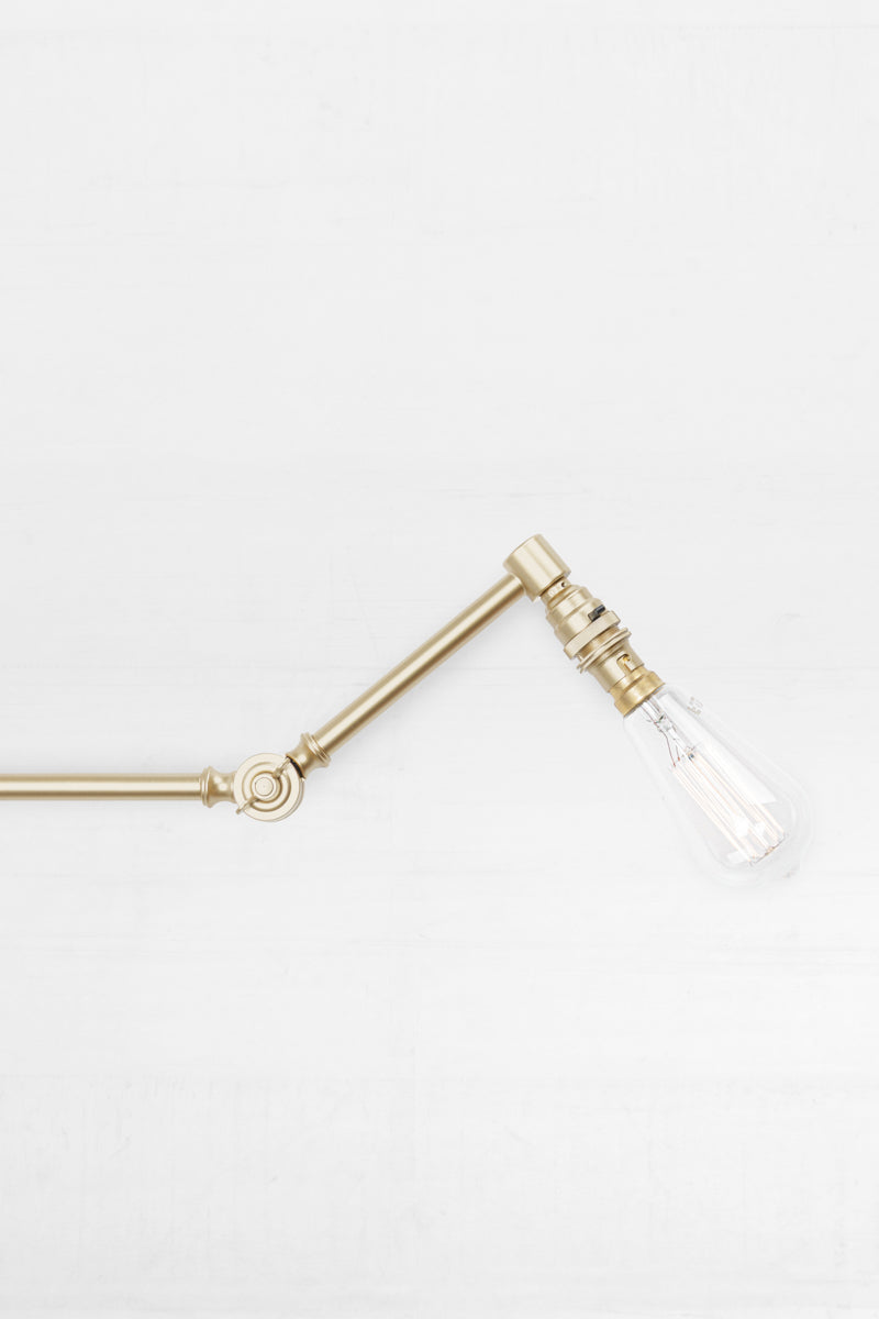 Swing Arm Light Fixture with Wall Plug in Brass Gold Finish, paired with a teardrop bulb