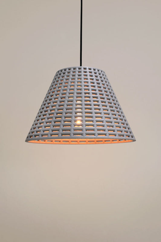 Pendant light with a shade constructed of concrete and a black cord.