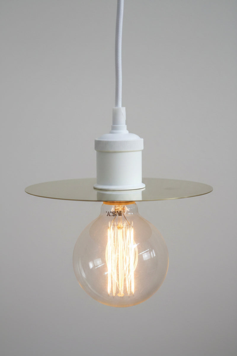 Small brass disc with a white pendant cord. 