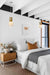 Three ceramic pendant lights with wooden blocks hanging over bedsides