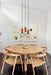 Three ceramic pendant lights with wooden blocks hanging over a dining table