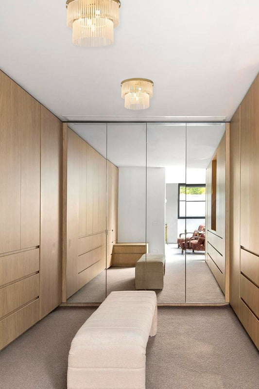 Two Tiered ceiling light with frosted glass steams and gold finished metalware installed in a dressing room. 