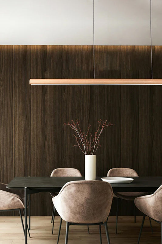 Large linear LED Pendant light in a naural finish over a dining space. 