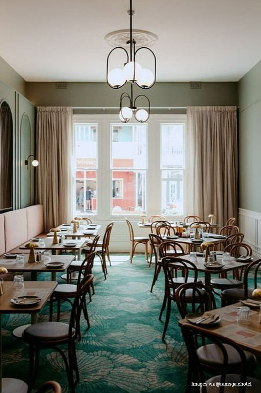 Dining room of the @ramsgatehotel with two black looped chandeliers with 3 opal glass ball shades. 
