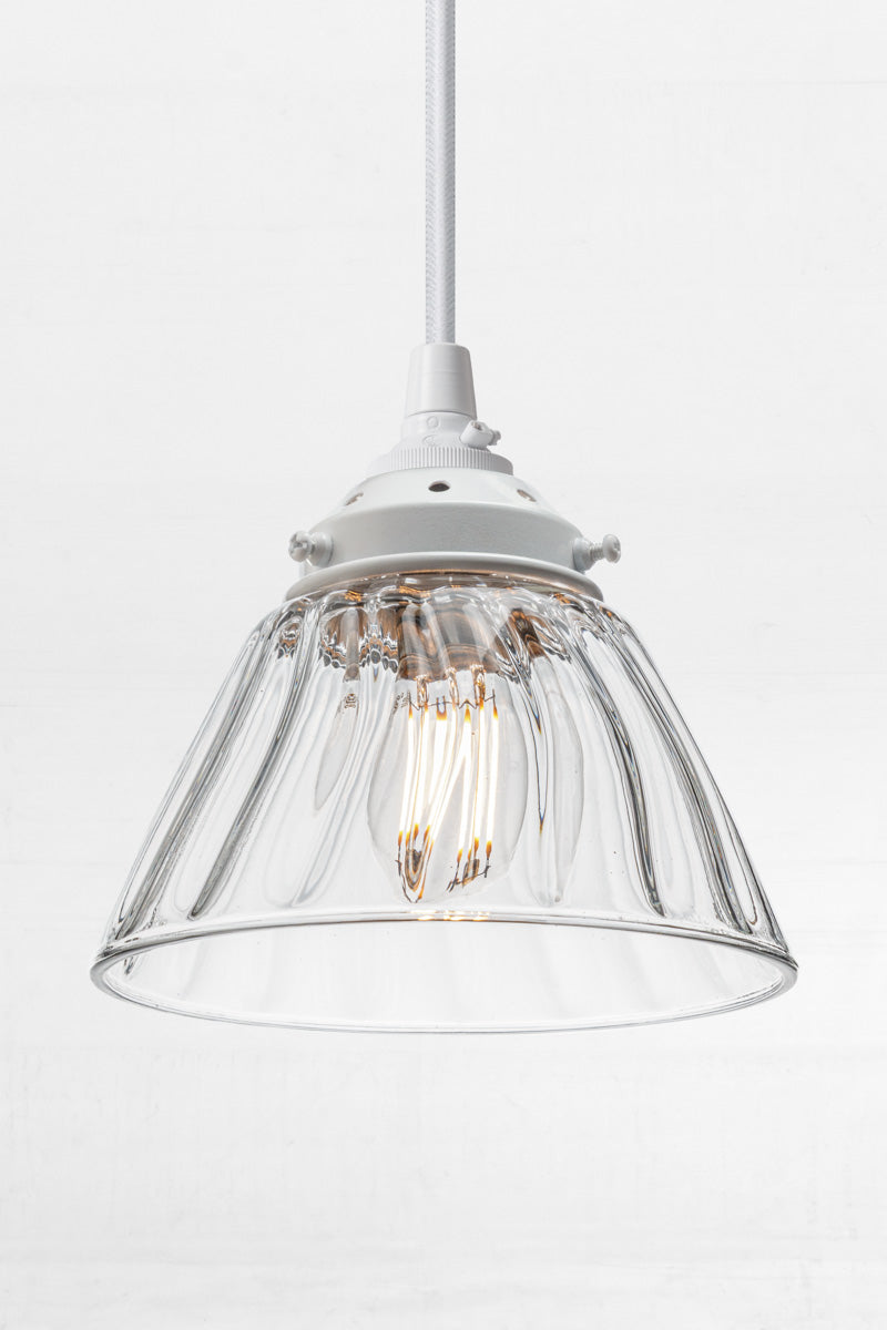 a tapered clear glass shade with a wide opening for maximum light dispersion