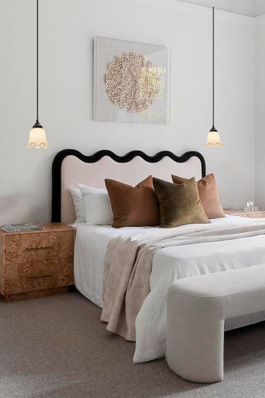 two pendants with scalloped edges, installed as bedside lighting. 