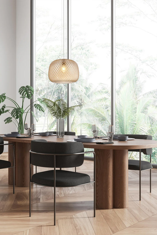 Intricately detailed amber glass pendant over a dining pace. 