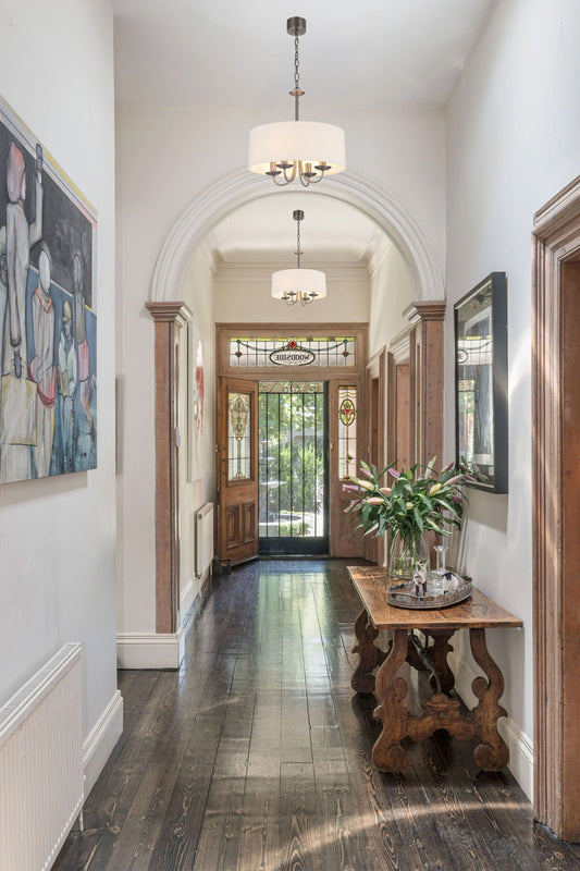  Two, four light nickel chandelier with fabric shade in an entrance way. 