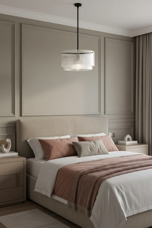 Tiered clear glass shades with fluted detailing paired with a black pole pendant suspension over a calm bedroom setting with taupe and pink tones.