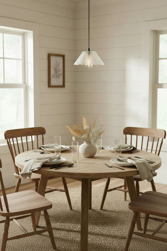 Dining room with wooden table, chairs, and a crackle glass pendant light.