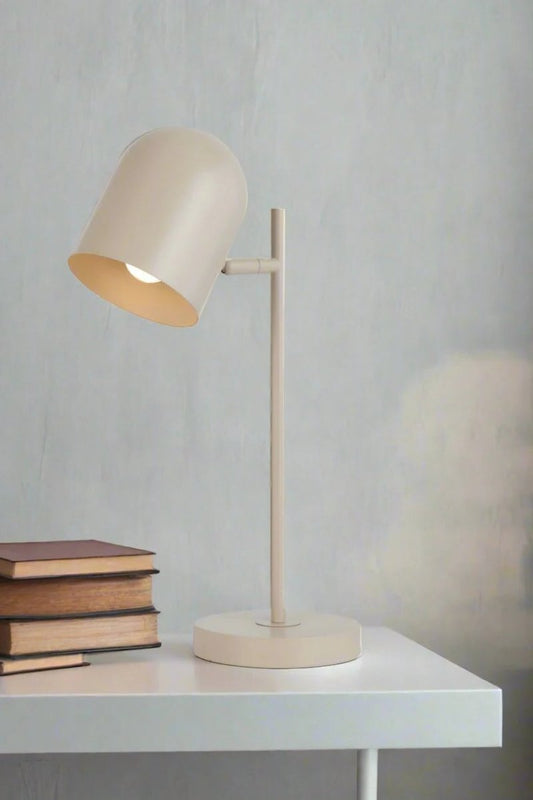 Khaki table lamp with adjustable head next to some books. 