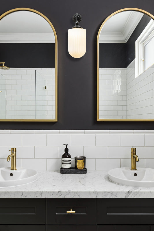wall light in bathroom next to mirrors