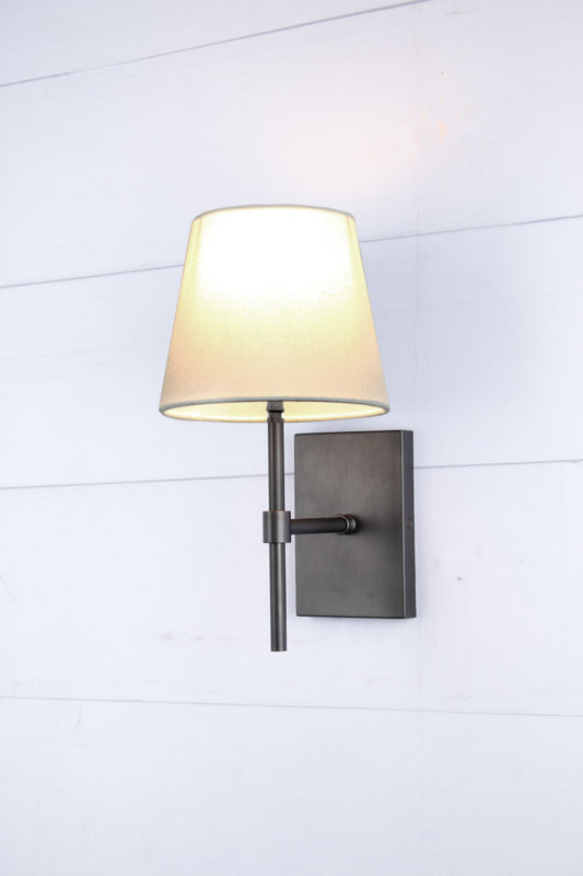 Antique bronze sconce with white linen shade.