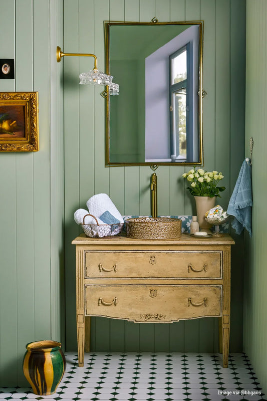 Image vis @bbgaus: Vintage clear glass shade on a gold/brass 90 degree wall arm in a green wall panelled bathroom with traditionally style vanity. 
