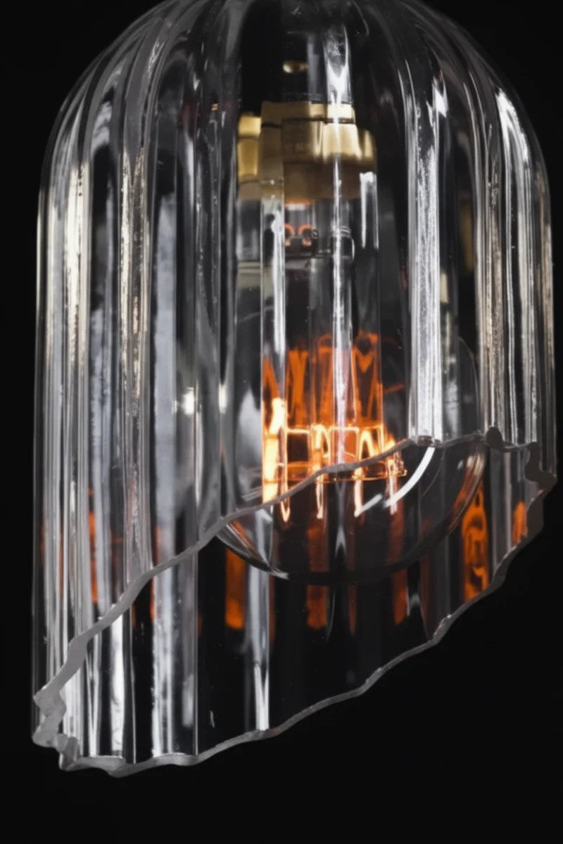 Video showcasing a clear fluted glass ahde with an elongated shae and an angled cut feature, paired with a clear bulb. 