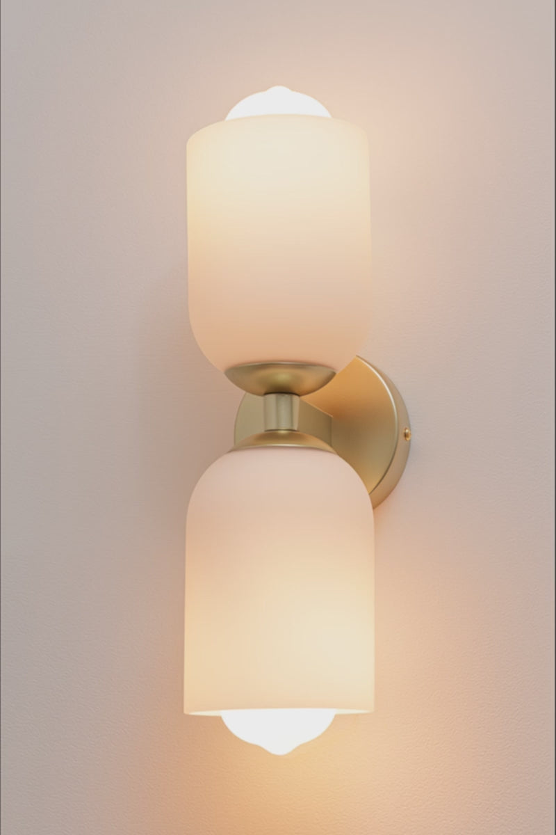 video of wall light showcasing gold brass fittings and two opal glass shades