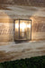 Brushed chrome outdoor wall sconce illuminating a cozy patio.