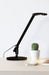 Table lamp in black finish with black cord on a flat surface
