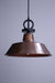 Pendant light with aged copper shade and black cord with disc