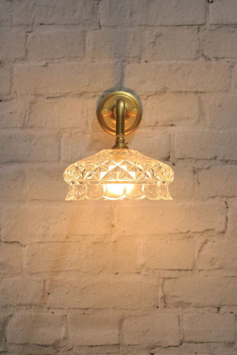 Gold/brass wall light with cut glass style shade