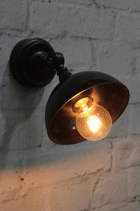 Bakelite wall light with black bowl shade in tilted position