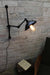 Swing arm wall light with black bakelight shade