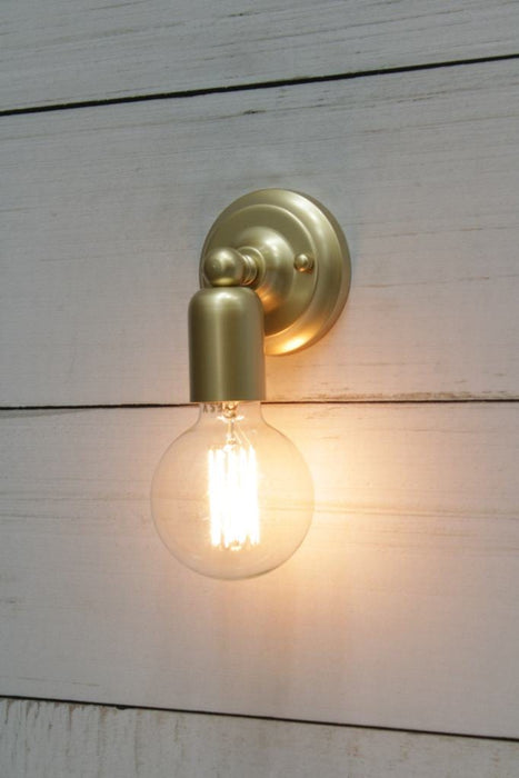 Bare bulb wall sconce in gold