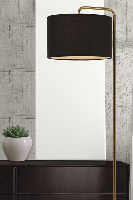 Floor lamp with gold/brass base and black fabric shade
