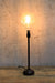 Black candlestick table lamp with ornate bulb
