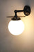 Black disc wall light with opal ball shade