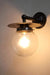Black disc wall light with clear ball shade