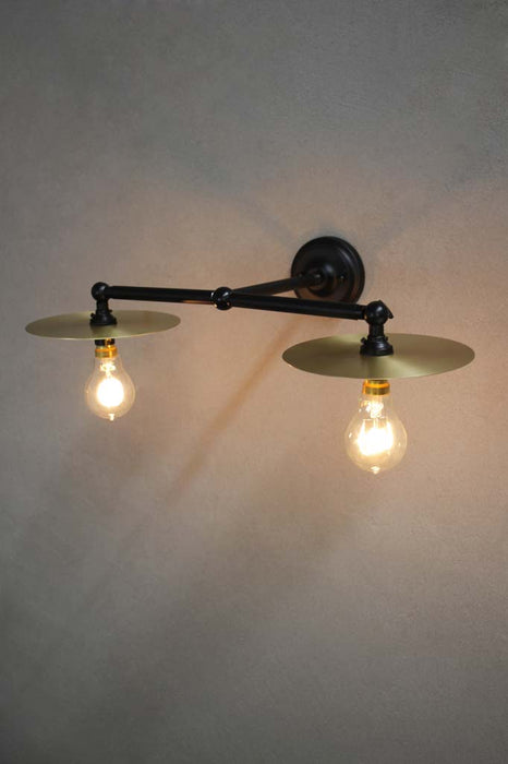Black double arm wall light with small brass discs