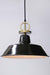 Black pendant light with gold cord and disc
