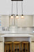 Black pendant light with small opal shades over kitchen island bench