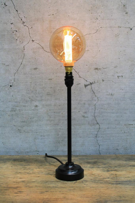 Black candlestick table lamp with amber bulb