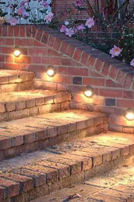 Brass LED step light in outdoor setting